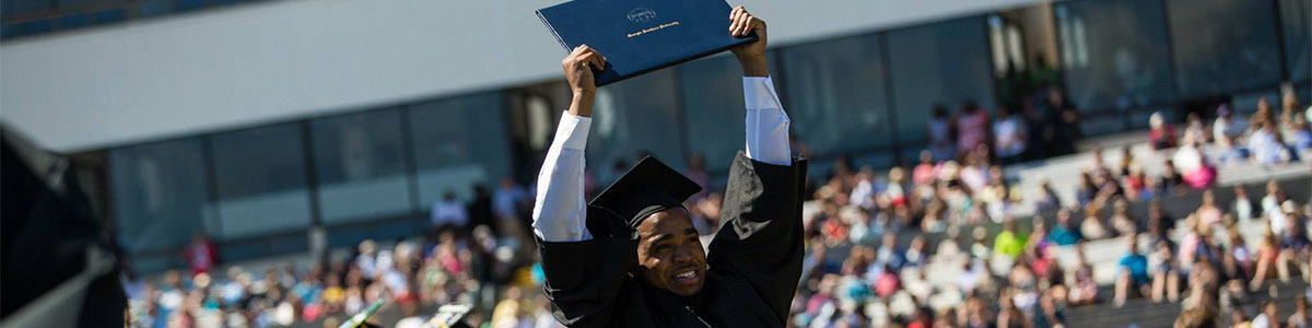 Graudating student holding up his diploma